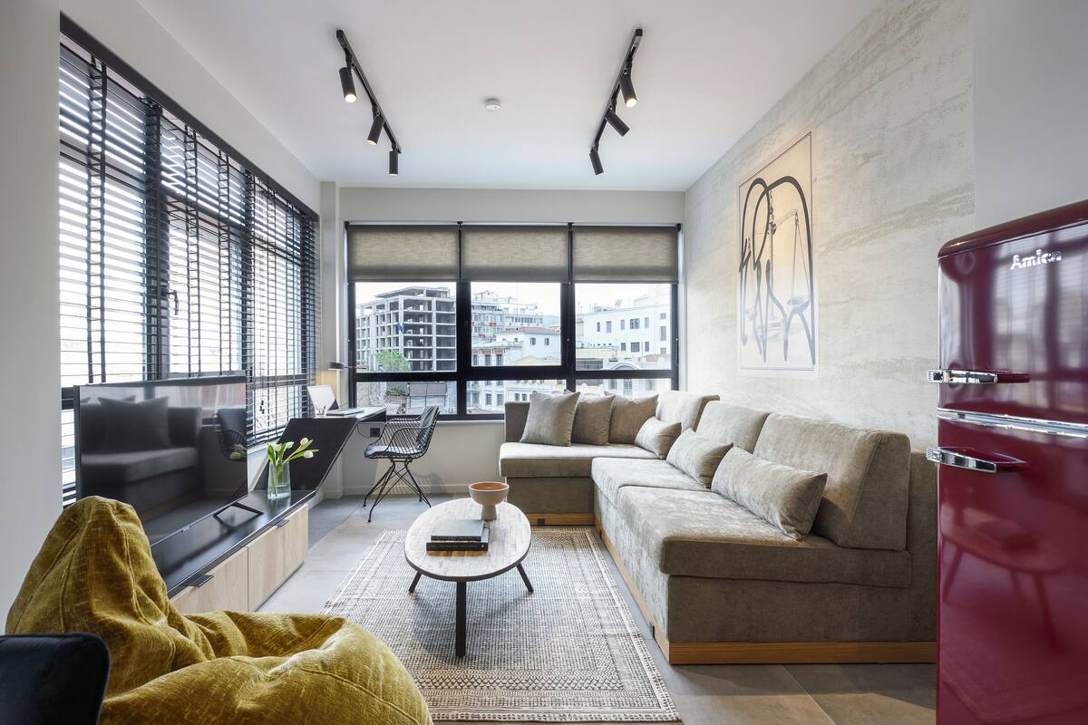 A modern living room with a sofa, coffee table, and a red cabinet.