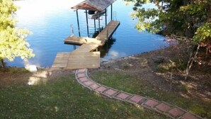 Un muelle de madera que se adentra en un lago, con una estructura cubierta al final.