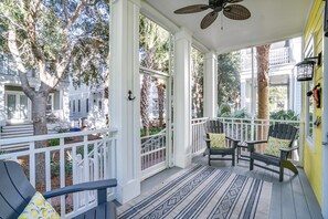 A covered porch with two chairs and a patterned rug. - 30A Beach House - Sunny Daze By Panhandle Getaways (Panama City Beach)