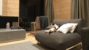 A cozy room with a sofa, a small table, and a cat. - Magnificent architect-designed chalet, breathtaking view of Mont Blanc (Hauteluce)