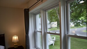 A hotel room with a large window, a bedside lamp, and a view of the outside. - Renovated Modern Gem w/AC – Walk to Cooperstown All-Star Village, Sleeps 6 (Oneonta)