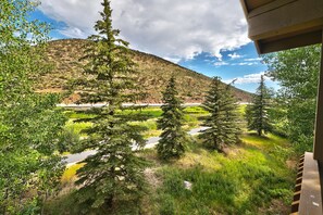 A view of a mountainous landscape with a road and trees.