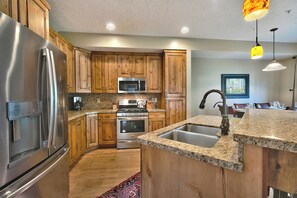 A kitchen with wooden cabinets, stainless steel appliances, granite countertops, and a built-in sink. - Central to World-Class Resorts - Private Hot Tub Managed by Park City Lodging (Park City)