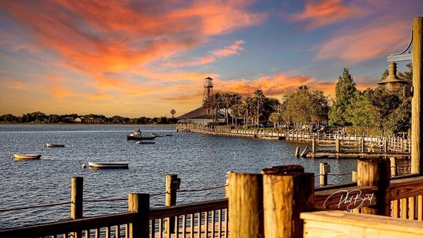 Vista al agua con barcos, un muelle de madera y un edificio con cúpula.
