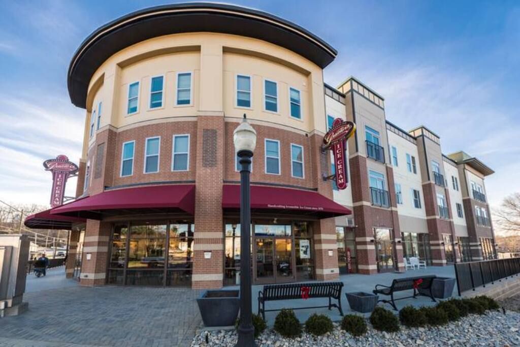 A multi-story hotel with a curved facade, large windows, and a red awning.