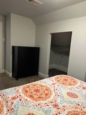 A bedroom with a bed, a dresser, and a closet. - Main, Three Bedroom House in Historic Loveland (Loveland)