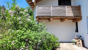 Un edificio con un balcone in legno, una finestra e un muro in pietra.