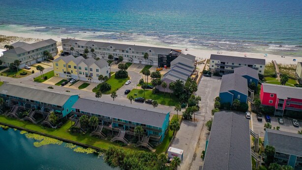 Un hôtel situé sur la côte, composé de plusieurs bâtiments, offrant une vue sur la plage et donnant accès à une marina.