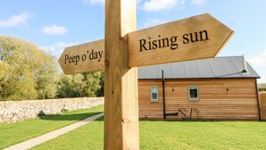 A wooden signpost with directional arrows pointing to 'Peep o'day' and 'Rising sun'. - Rising Sun (York)