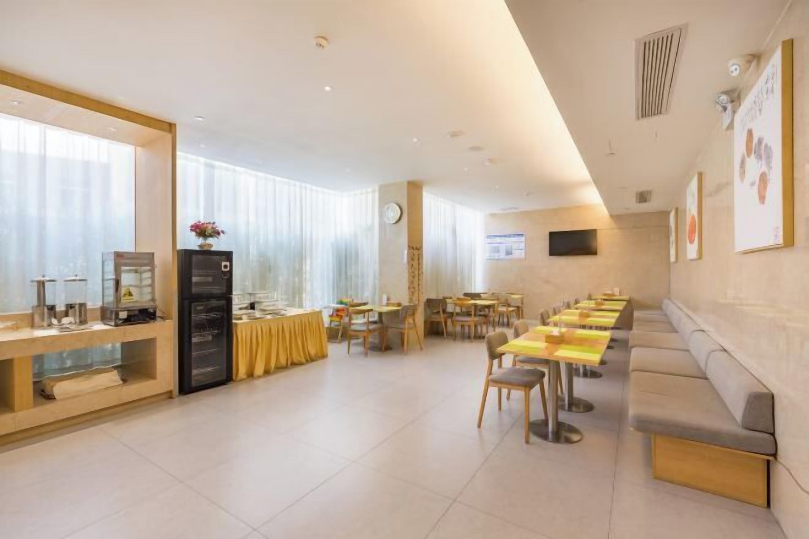 A hotel dining area with multiple tables and a long bench along the wall.