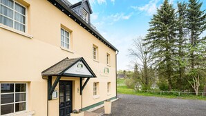 A building with a green entrance, a sign reading "Landhaus Porschensheim," and a gravel driveway. - Landhaus Purschenstein (Neuhausen)