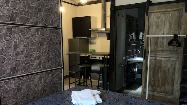 Een slaapkamer met een bed, een badkamer en een kitchenette.
