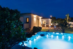 Una casa moderna con piscina al anochecer.