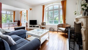 Un salon spacieux avec une grande télévision, des sièges confortables et une cheminée.