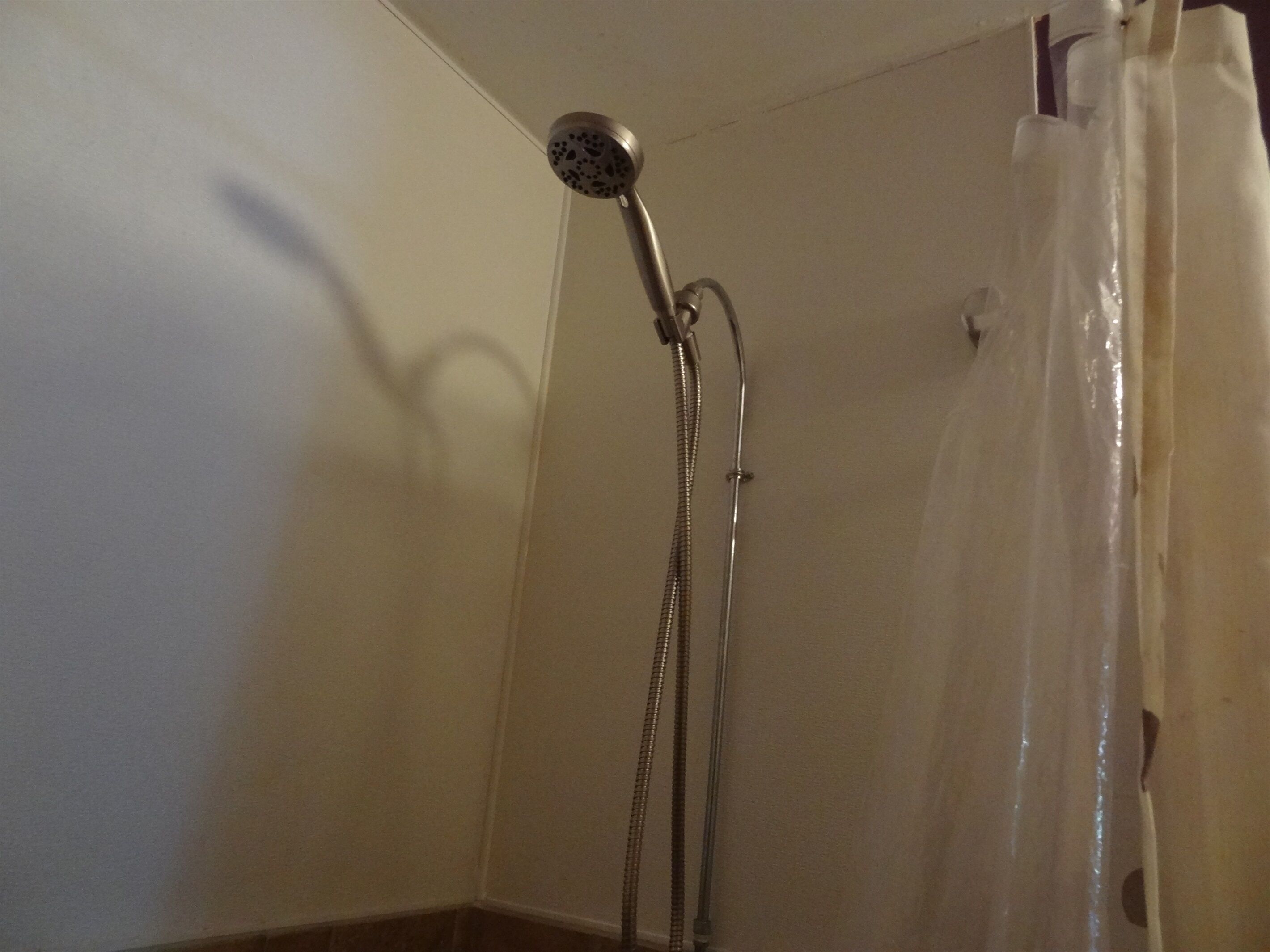 A shower with a handheld showerhead and a flexible hose.