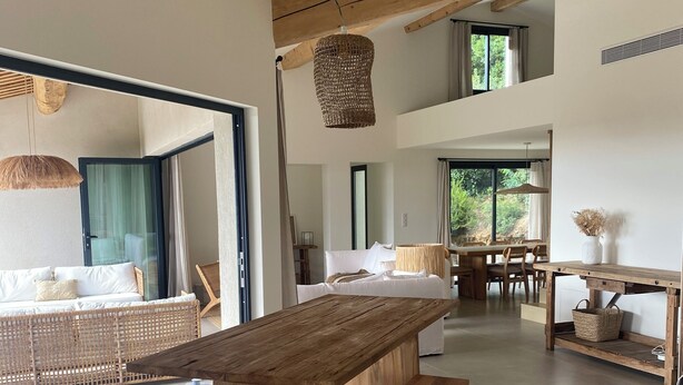 A spacious, modern interior with a large wooden dining table, a cozy seating area, and a view of the outdoors. - "La Chamade" – 180° ocean view – 6 bedrooms – heated pool – near St. Tropez (LA CROIX VALMER)