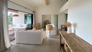 A spacious living area with a high ceiling, a wooden bench, and a large window. - "La Chamade" – 180° ocean view – 6 bedrooms – heated pool – near St. Tropez (LA CROIX VALMER)