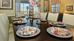 A dining table set with plates, candles, and a centerpiece.