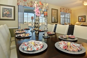 Una mesa de comedor dispuesta con platos, velas y un centro de mesa.