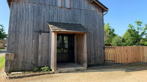 A rustic wooden barn with a large door and a small porch. - Tobacco drying shed renovated into a loft, at CAPDROT in Périgord Pourpre (CAPDROT)