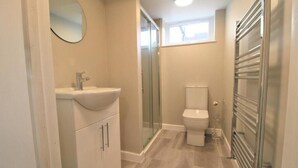 A bathroom with a sink, toilet, and glass shower enclosure.