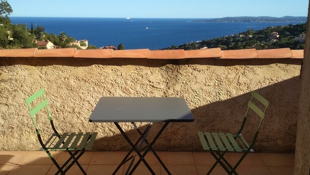 A terrace with a table and two chairs, overlooking a coastal view. - Moulin à vent 3429 villa (Les Issambres)