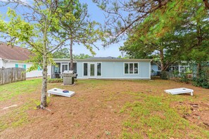A residential property with a detached house, a backyard with a grill, and a fenced yard. - A Little Peace of Paradise- 3 Bed/2 Bath House -Walk to Beach-Screened In Porch (North Myrtle Beach)