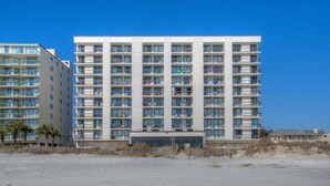 A multi-story hotel with a modern design, featuring a uniform facade and numerous balconies.