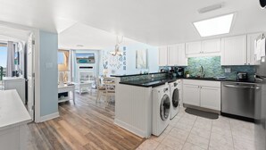 A modern kitchen with a central island, built-in appliances, and a view to the dining area.