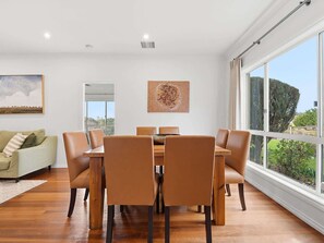 Un comedor con una mesa y sillas, un sofá y un cuadro en la pared.