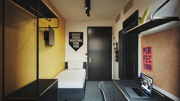 Una habitación de hotel moderna con cama, escritorio y computadora portátil, con un letrero que dice 'Right Here Waiting for You' y un tablón de anuncios con un letrero que dice 'Perfect'.