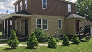 A two-story residential building with a covered porch and a small attached garage.