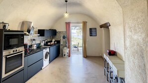Una cocina con horno empotrado, microondas y lavadora.