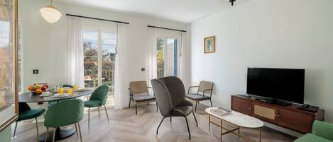 Una sala de estar moderna con televisión, sofá y comedor.
