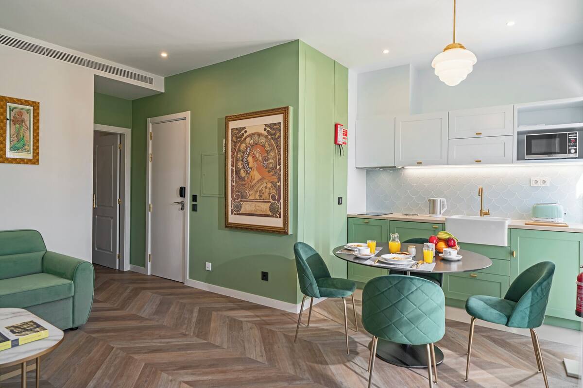 Uma cozinha moderna com micro-ondas, pia e área de refeições com mesa e cadeiras.
