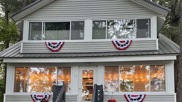 A two-story house with a front porch, a staircase, and a number '17' on the door. - Cozy 3 bedroom seasonal cottage with very short walk to private community beach (Windham)
