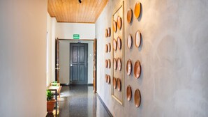 A hallway with a polished floor, a wooden ceiling, and a wall decorated with circular mirrors.