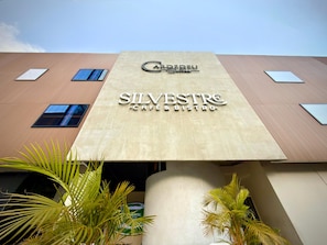 Un edificio con un letrero que dice 'SILVESTRE CAFE & BISTRO' y el logo de 'CARIBEU' arriba.