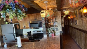 A kitchen with granite countertops, stainless steel appliances, and wooden cabinets. - Tiki Themed Condo on Tampa Bay (Tampa)