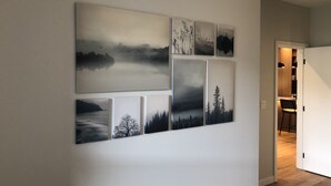 A hallway with a series of landscape paintings on the wall. - Luxury Condo - Easy Walk to Downtown, Ocean & Attractions (Victoria)