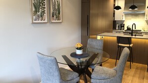 A modern kitchen with a central island, dark cabinets, and pendant lighting. - Luxury Condo - Easy Walk to Downtown, Ocean & Attractions (Victoria)