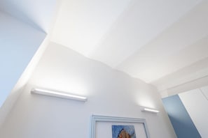 Une pièce aux murs blancs, ornée d’un tableau encadré et dotée d’un éclairage encastré.