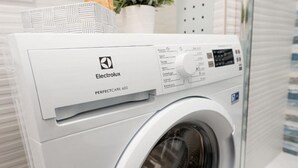 Vue de face d’un lave-linge Electrolux PERFECTCARE 600, avec son panneau de commande et sa porte avant.