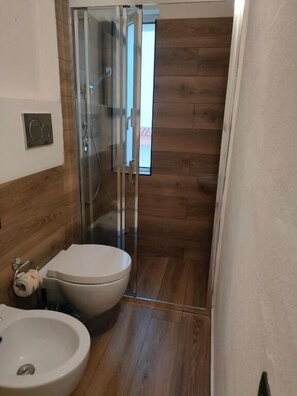 Een douche, een haardroger, een bidet, handdoeken
