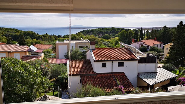 Un barrio residencial con casas, vista al mar y zonas verdes.