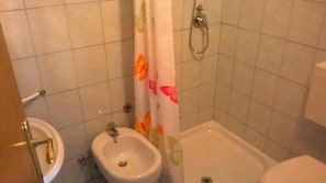 Un baño con bidé, inodoro y bañera.
