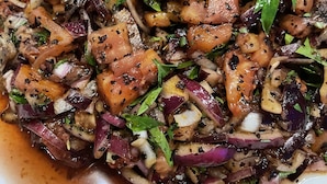 Ein Teller Essen mit verschiedenen Zutaten, darunter Fleisch, Gemüse und einer Dekoration.