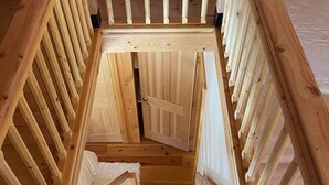 A wooden staircase with a view of the upper floor. - Post and Beam Carriage House in the heart of Mad River Valley (Waitsfield)