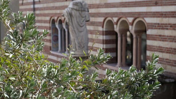 A statue in front of a building with striped brick walls and arched windows. - Domus Nova - Three Bedroom Apartment, Sleeps 6 (Verona)