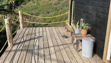 Puinen terassi, jossa on köysiaita, ruukkukasveja ja taustalla näkyvä rakennus.